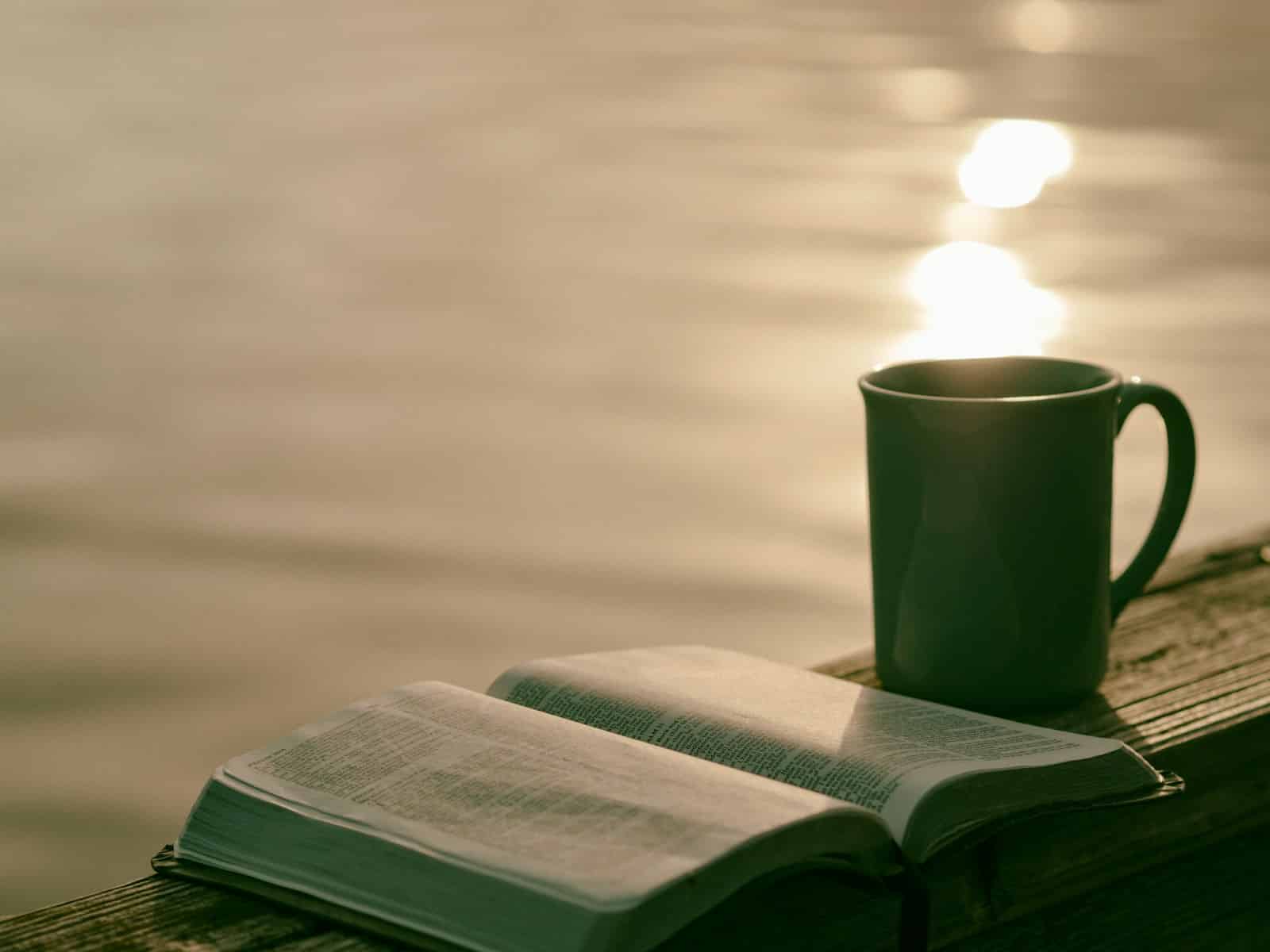 green ceramic mug beside book best christian publishers